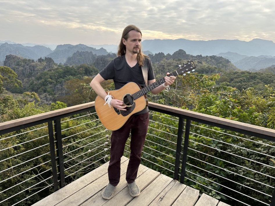 Keith Kenny playing guitar on a deck